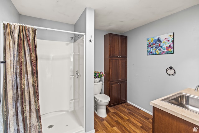 bathroom with hardwood / wood-style floors, vanity, curtained shower, and toilet