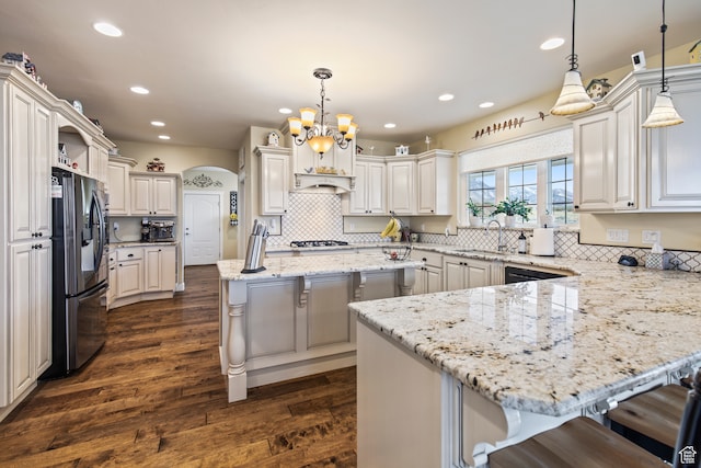 kitchen with a kitchen breakfast bar, a center island, stainless steel appliances, and decorative light fixtures