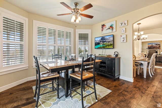 dining area featuring dark hardwood / wood-style floors, ceiling fan with notable chandelier, and a wealth of natural light