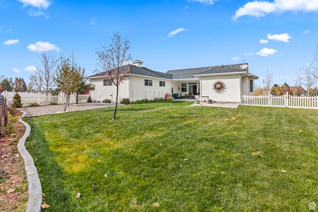 rear view of house with a yard and a patio