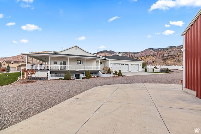 view of front of home featuring a mountain view, a porch, and a garage