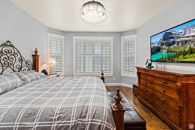 bedroom with hardwood / wood-style floors and a notable chandelier