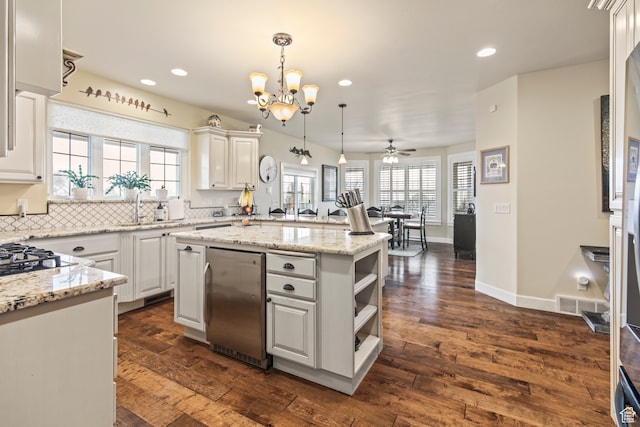 kitchen with white cabinets, a kitchen island, dark wood-type flooring, and a wealth of natural light