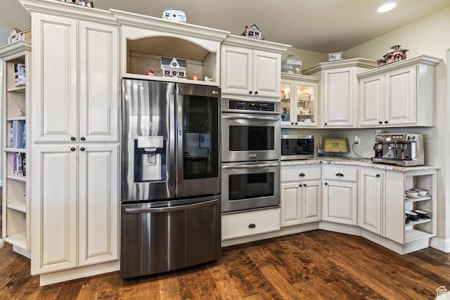 kitchen with white cabinets, light stone counters, dark hardwood / wood-style flooring, and stainless steel appliances