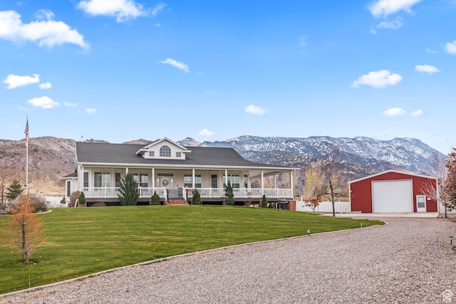 view of front facade with a mountain view, a porch, an outdoor structure, and a garage