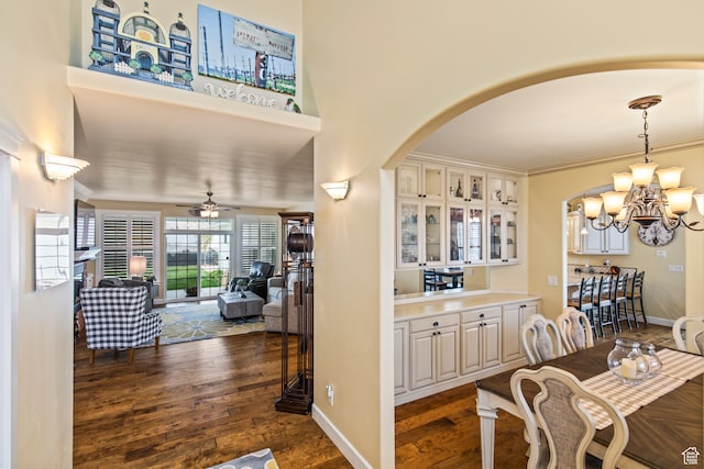 dining space featuring ceiling fan with notable chandelier, dark hardwood / wood-style flooring, and crown molding