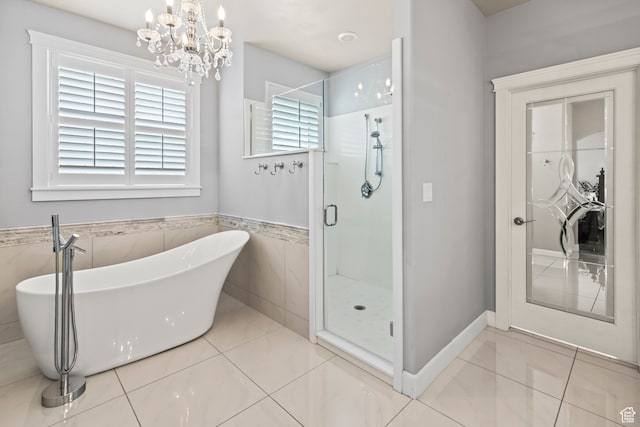 bathroom with tile patterned floors, separate shower and tub, and a notable chandelier