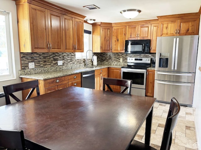 341 S 3rd W, Soda Springs, ID 83276 - kitchen featuring appliances with stainless steel finishes, backsplash, light stone counters, and sink