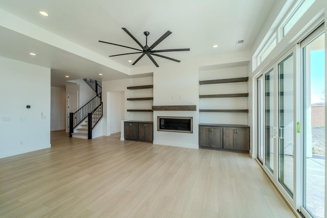 3092 E 2110th St S, St George, UT 84790 - unfurnished living room with stairs, light wood-type flooring, healthy amount of natural light, a glass covered fireplace, and recessed lighting