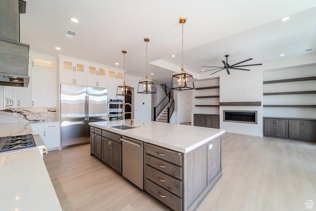 3092 E 2110th St S, St George, UT 84790 - kitchen with appliances with stainless steel finishes, a sink, a ceiling fan, light wood-style flooring, and white cabinetry