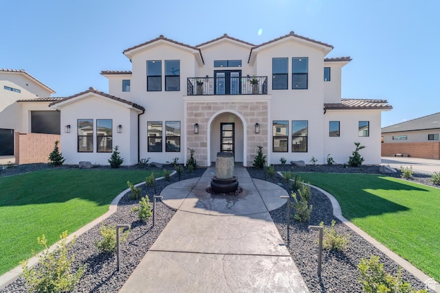 3092 E 2110th St S, St George, UT 84790 - mediterranean / spanish-style house featuring a balcony, a front lawn, a tiled roof, and stucco siding