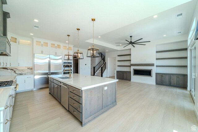 3092 E 2110th St S, St George, UT 84790 - kitchen featuring appliances with stainless steel finishes, a sink, light wood finished floors, a fireplace, and recessed lighting