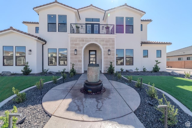 3092 E 2110th St S, St George, UT 84790 - mediterranean / spanish-style house featuring a balcony, a front yard, a tile roof, and stucco siding