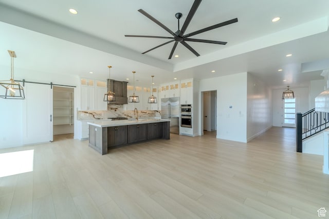 3092 E 2110th St S, St George, UT 84790 - kitchen with premium range hood, a large island, light countertops, a barn door, and freestanding refrigerator