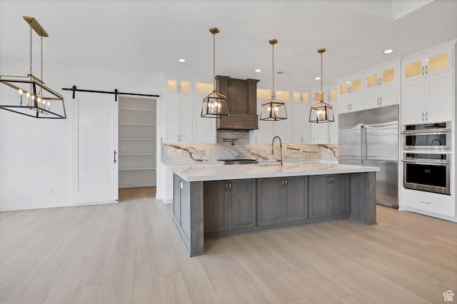 3092 E 2110th St S, St George, UT 84790 - kitchen featuring stainless steel appliances, a chandelier, tasteful backsplash, light wood finished floors, and a barn door