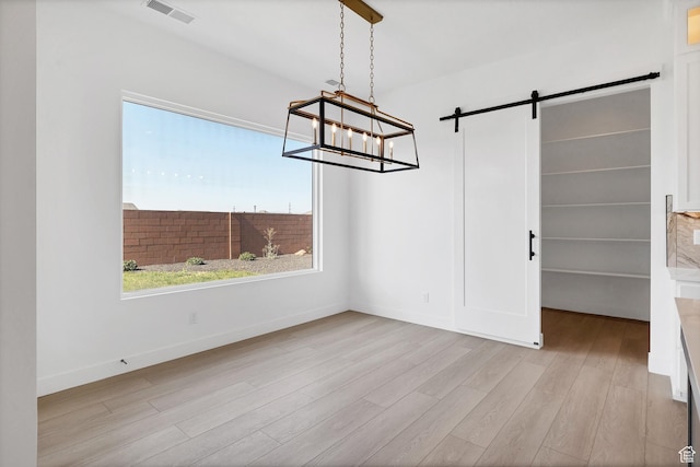 3092 E 2110th St S, St George, UT 84790 - unfurnished dining area with wood finished floors, a chandelier, and a barn door
