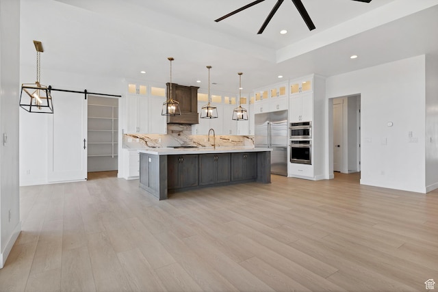 3092 E 2110th St S, St George, UT 84790 - kitchen featuring appliances with stainless steel finishes, light countertops, a barn door, backsplash, and white cabinetry