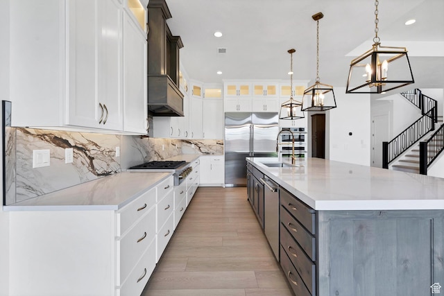 3092 E 2110th St S, St George, UT 84790 - kitchen with appliances with stainless steel finishes, light wood-style flooring, white cabinets, a chandelier, and recessed lighting