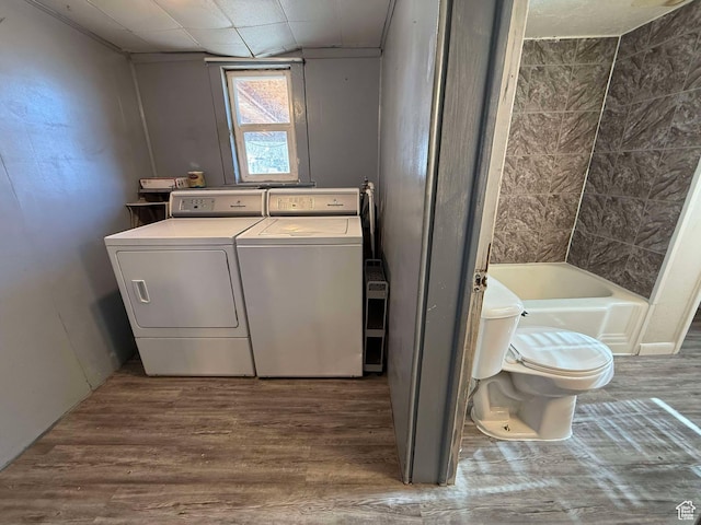 laundry room with wood-type flooring and independent washer and dryer