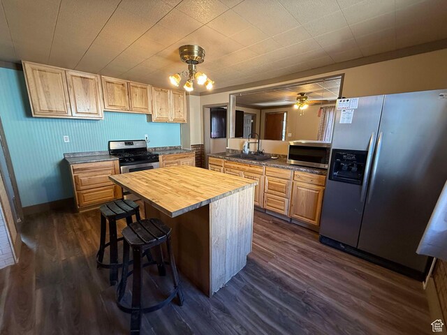 kitchen with a breakfast bar, butcher block counters, sink, dark hardwood / wood-style flooring, and stainless steel appliances