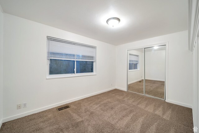 unfurnished bedroom with carpet floors and a closet