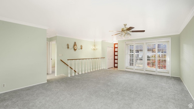 spare room with ceiling fan with notable chandelier, ornamental molding, carpet, and baseboards
