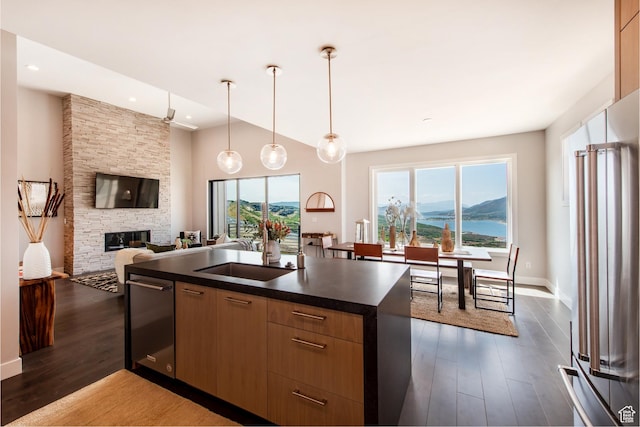 11785 N Apex Way Unit 60, Hideout, UT 84036 - kitchen with appliances with stainless steel finishes, dark countertops, open floor plan, dark wood finished floors, and a stone fireplace