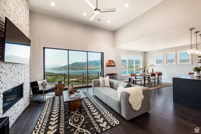 11785 N Apex Way Unit 60, Hideout, UT 84036 - living area with a ceiling fan, a towering ceiling, dark wood-type flooring, a fireplace, and recessed lighting