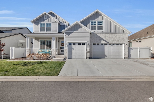 view of front of house with covered porch, a garage, and a front yard