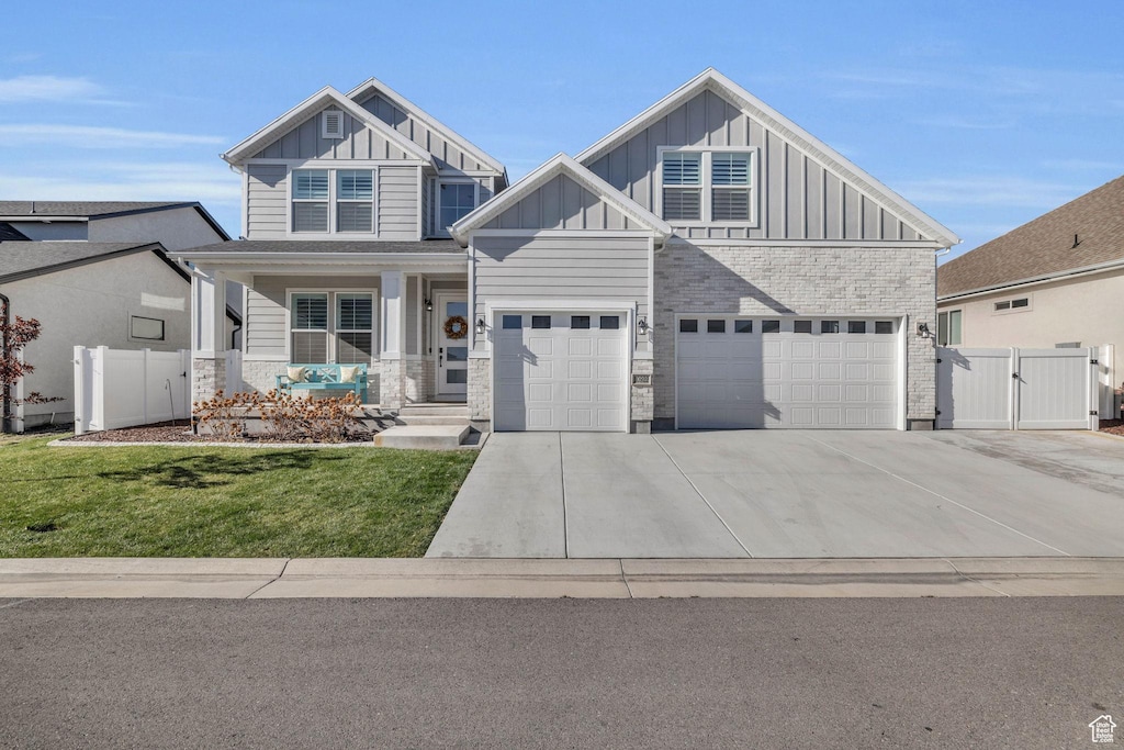 10922 S Glamis Dune Dr, South Jordan, UT 84009 - craftsman-style house featuring board and batten siding, concrete driveway, a gate, a porch, and a garage