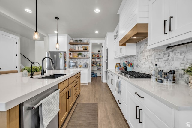 kitchen with a large island, decorative light fixtures, light stone counters, and white cabinetry