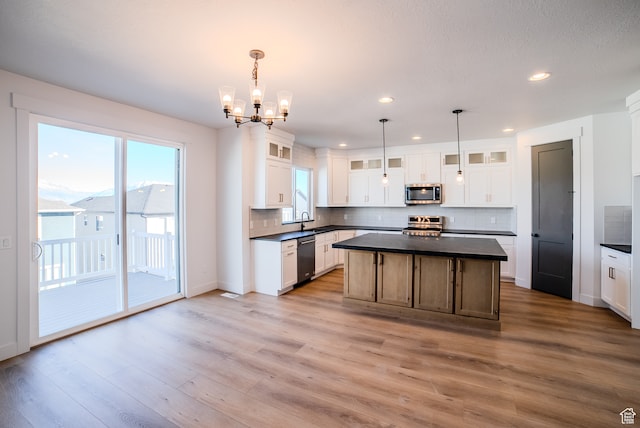 kitchen featuring white cabinets, appliances with stainless steel finishes, a center island, and pendant lighting