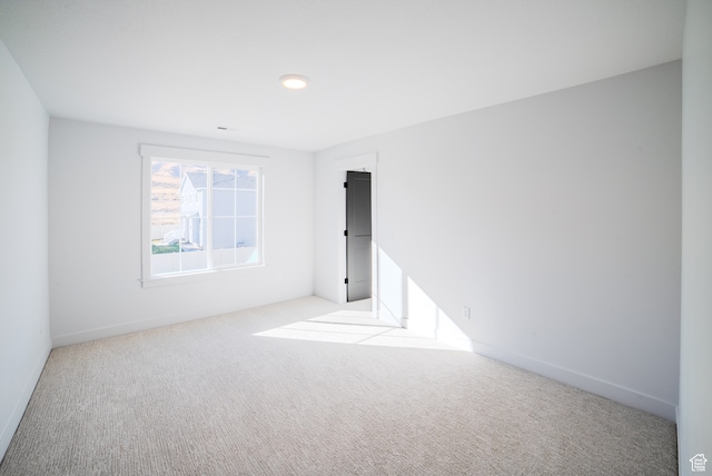 spare room featuring light carpet