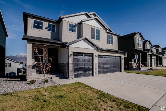 view of front of property featuring a front yard, a mountain view, and a garage