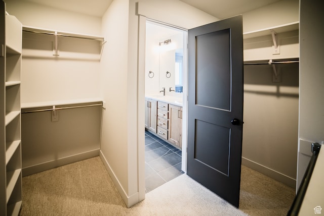 walk in closet featuring sink and carpet floors