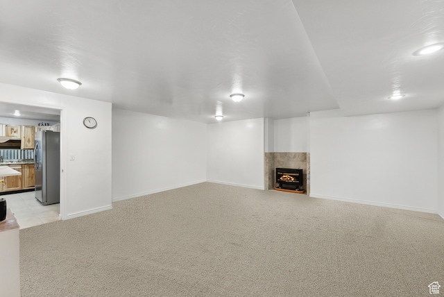 unfurnished living room featuring a fireplace and light colored carpet