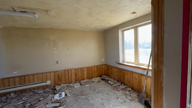 miscellaneous room featuring wood walls and a baseboard heating unit