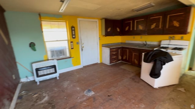 kitchen with dark brown cabinetry, white range with gas cooktop, and heating unit