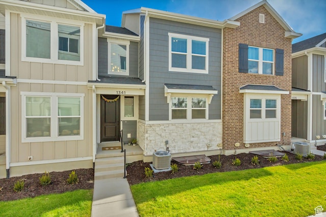 view of front of house with cooling unit and a front lawn