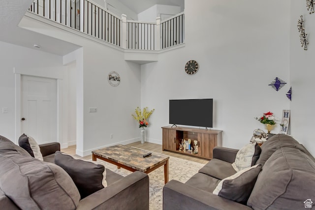 living room with a high ceiling and light hardwood / wood-style flooring