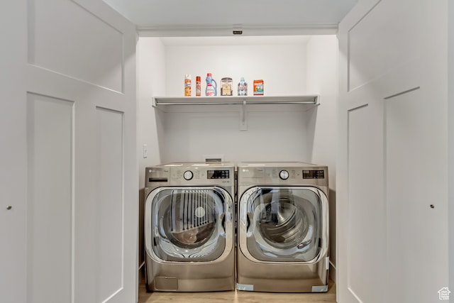 washroom with washer and dryer and light hardwood / wood-style floors