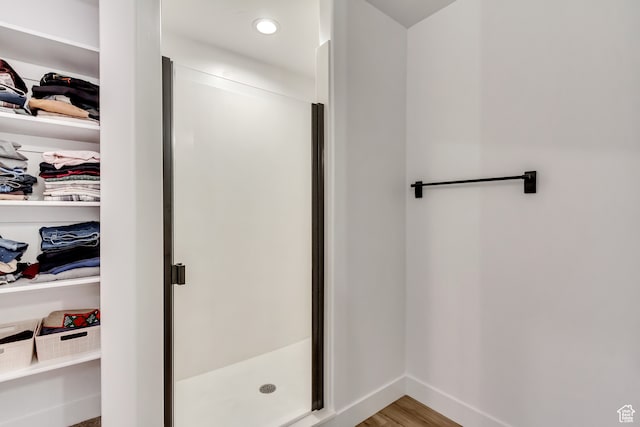 bathroom with hardwood / wood-style floors and an enclosed shower