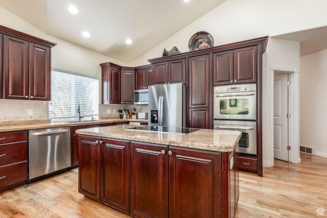 618 E Draper Heights Way S, Draper, UT 84020 - kitchen with lofted ceiling, sink, light wood-type flooring, appliances with stainless steel finishes, and a kitchen island