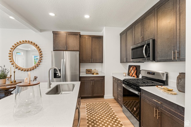 1044 E 1930 S Unit 419, Heber City, UT 84032 - kitchen featuring appliances with stainless steel finishes, a textured ceiling, dark brown cabinetry, light wood-style floors, and recessed lighting