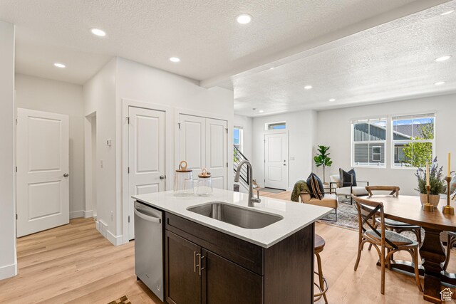 1044 E 1930 S Unit 419, Heber City, UT 84032 - kitchen with dishwasher, light wood-style flooring, dark brown cabinetry, a center island with sink, and light countertops