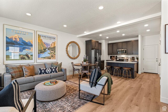 1044 E 1930 S Unit 419, Heber City, UT 84032 - living room featuring recessed lighting, light wood-style flooring, a textured ceiling, and beam ceiling