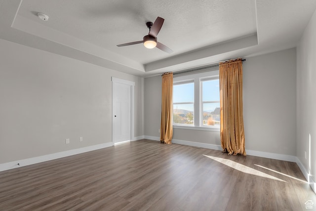 2388 E Horizon Dr Unit 907, Eagle Mountain, UT 84005 - spare room featuring a tray ceiling, wood finished floors, ceiling fan, a textured ceiling, and baseboards