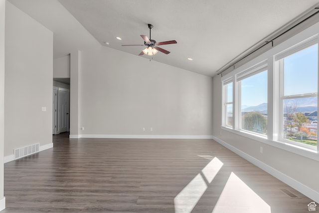 spare room featuring a mountain view, dark hardwood / wood-style flooring, and vaulted ceiling