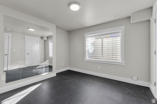 spare room with a textured ceiling