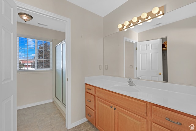 bathroom featuring tile patterned flooring, vanity, and an enclosed shower